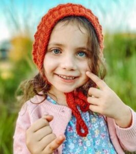 Ivy-Mae, aos 4 anos, sorridente com sua prótese ocular.