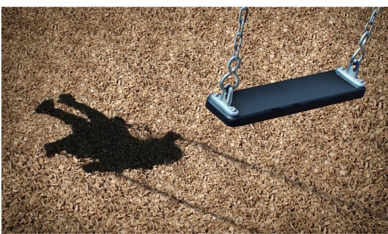Imagem de um chão de areia com uma sombra de um balanço com uma criança mas no balanço não há criança