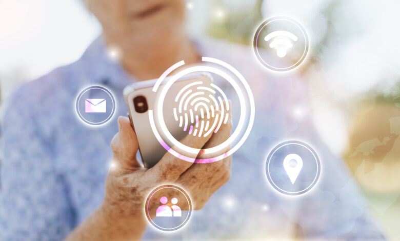 Mulher idosa branca de blusa azul segurando um celular olhando para ele, com ícones em branco pela imagem, e no centro a imagem de uma digital